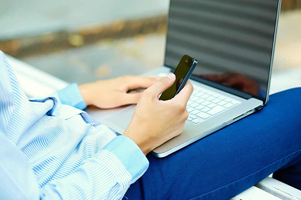 Professional completing Microsoft MFA authentication on a laptop and phone